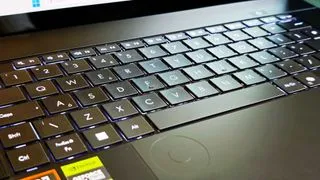 A black ASUS ProArt P16 laptop on a green sofa