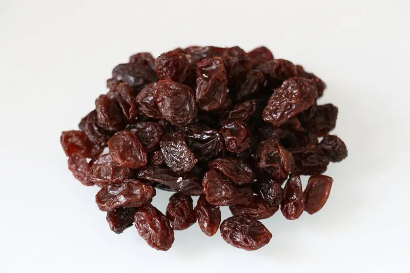 A bowl of dried raisins, emphasizing their concentrated toxicity for dogs.
