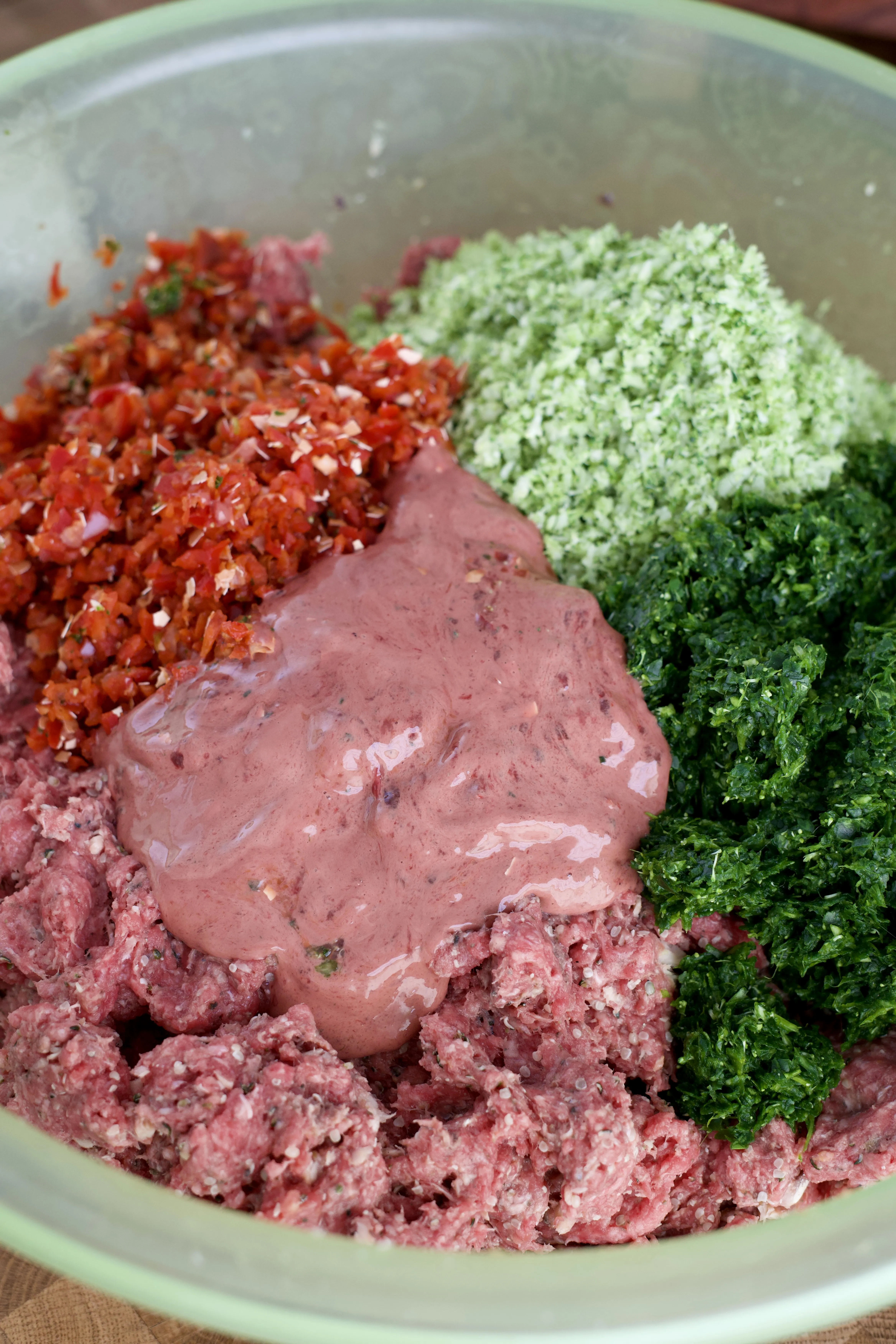 A bowl of homemade dog food with mixed ingredients and fresh vegetables