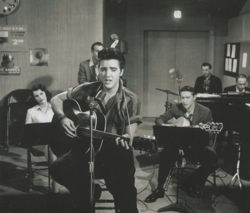 A candid shot of Elvis Presley on the set of Jailhouse Rock, showing his charisma and energy.