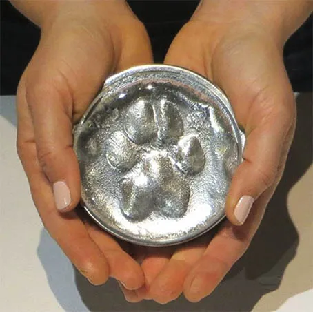 A close-up of a glass paw print keepsake