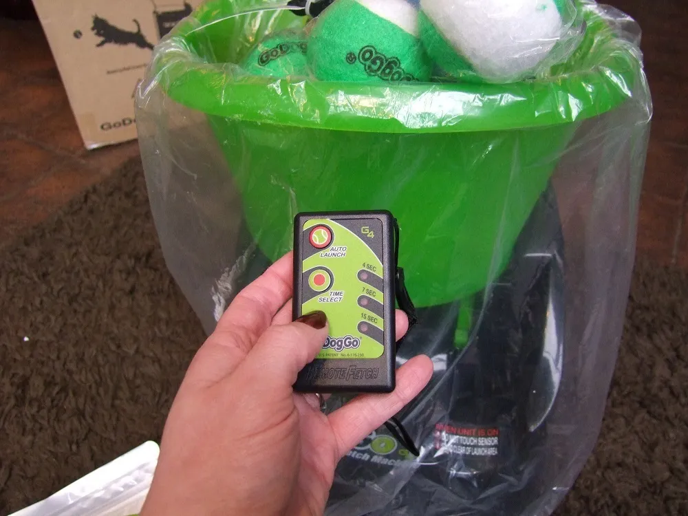 A close-up of the control panel on the GoDogGo G4 automatic dog ball launcher, showing power and timing settings