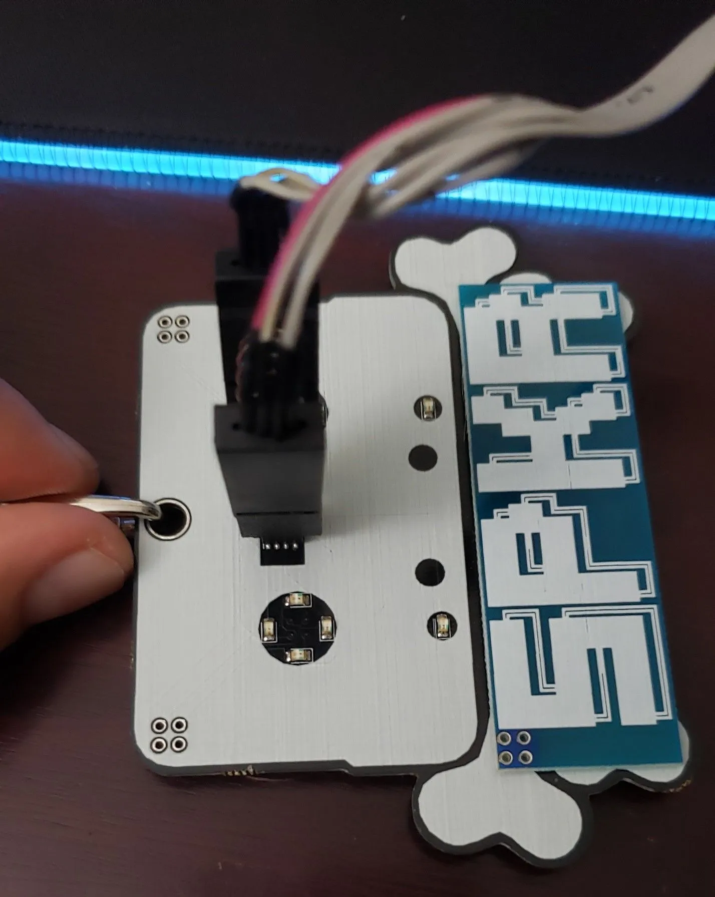 A conference speaker badge with an ATtiny85 microcontroller, successfully connected to a SOIC clip, ready for hardware firmware extraction