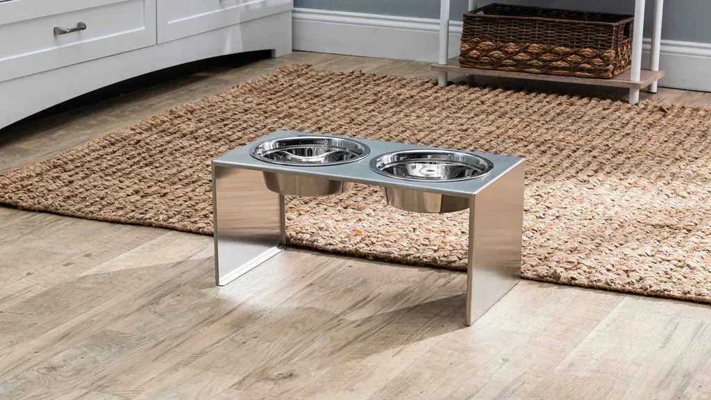 A dog happily eating from an elevated dog bowl stand