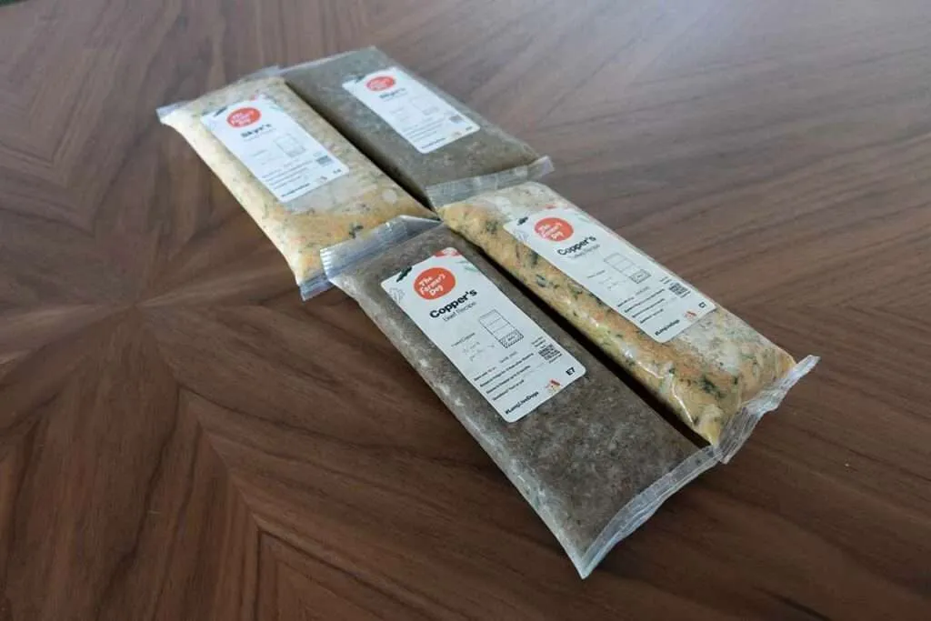 A dog looking somewhat unimpressed by a traditional dog food bag