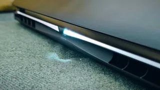 A Gigabyte Aorus Master 16 laptop on a green sofa