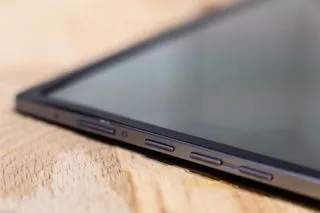 A graphic designer using the ASUS ZenScreen MQ16AH portable monitor in a mobile workspace setting