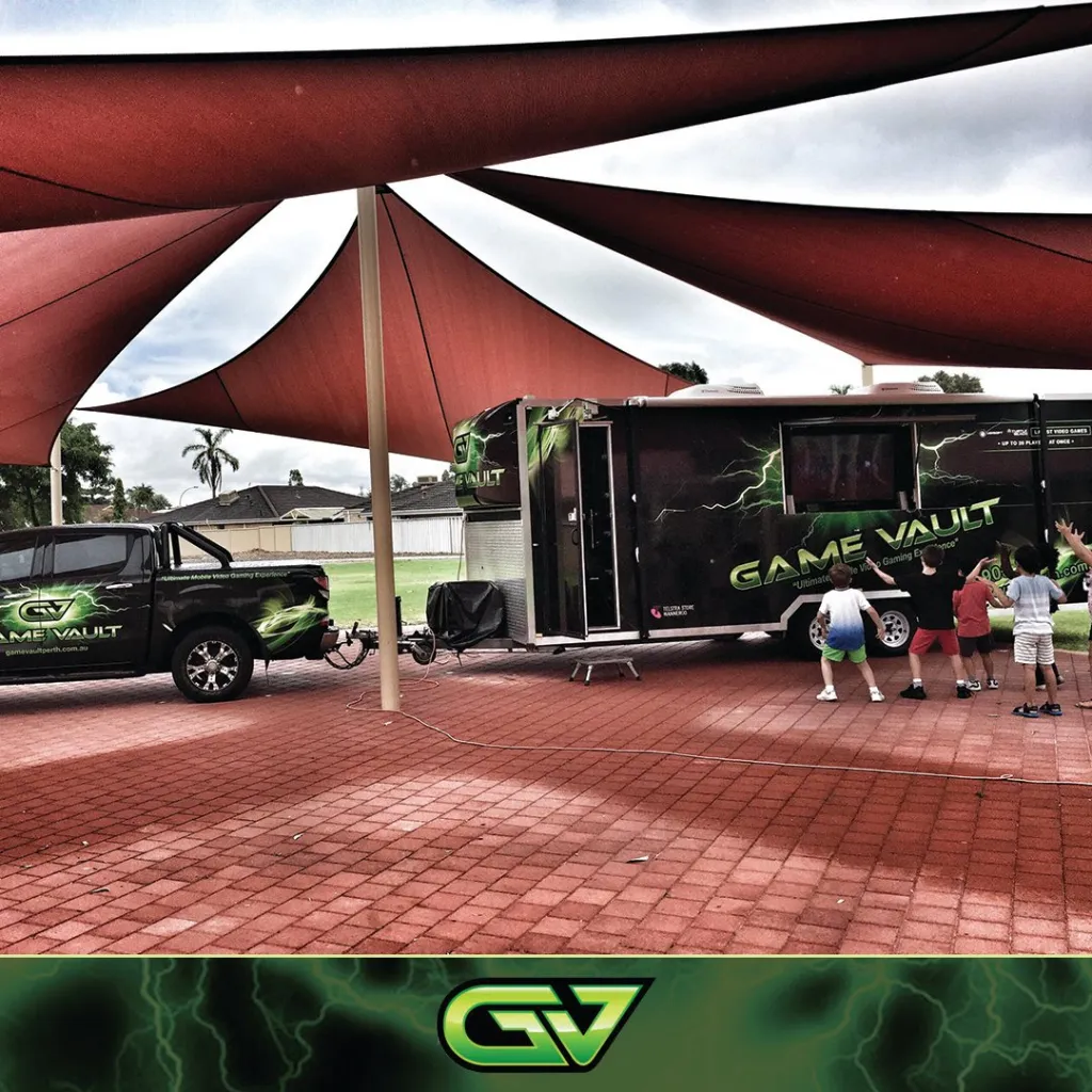 A group of children inside the Game Vault gaming van, enthusiastically playing video games and enjoying the immersive experience.