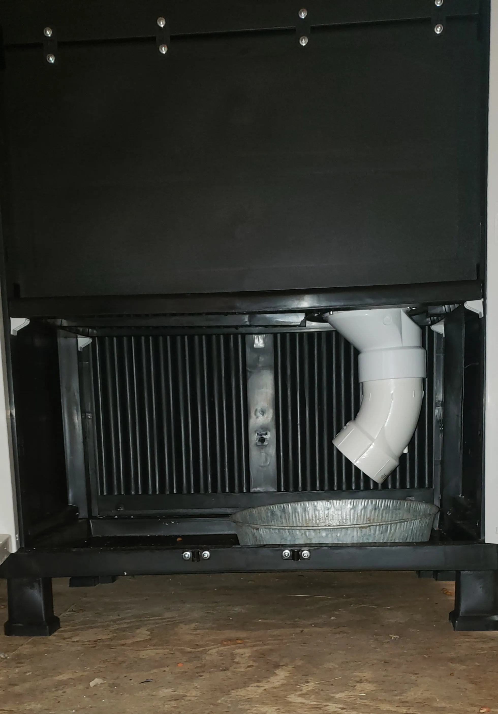 A person cleaning the parts of an extra large automatic dog feeder.