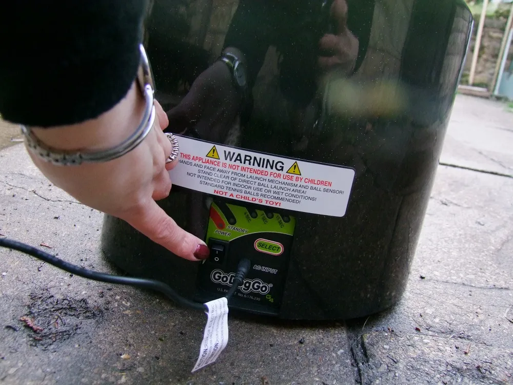 A remote control for the GoDogGo automatic ball launcher, indicating hands-free operation