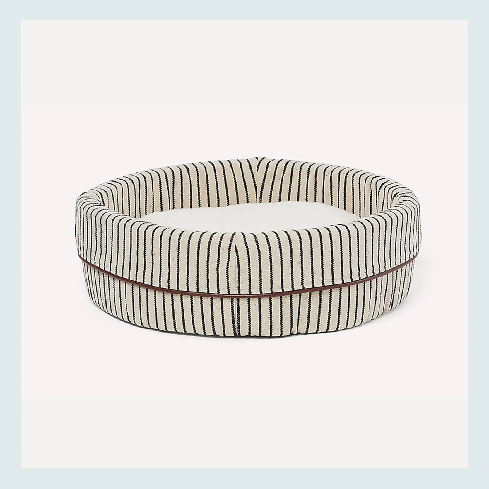 A round, fluffy cat bed in a soft blue color