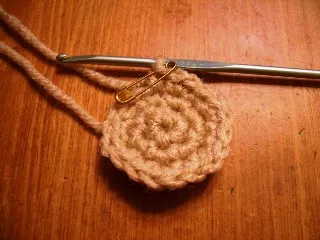 A small, brown and black crochet dog resembling a teacup Yorkie sitting upright