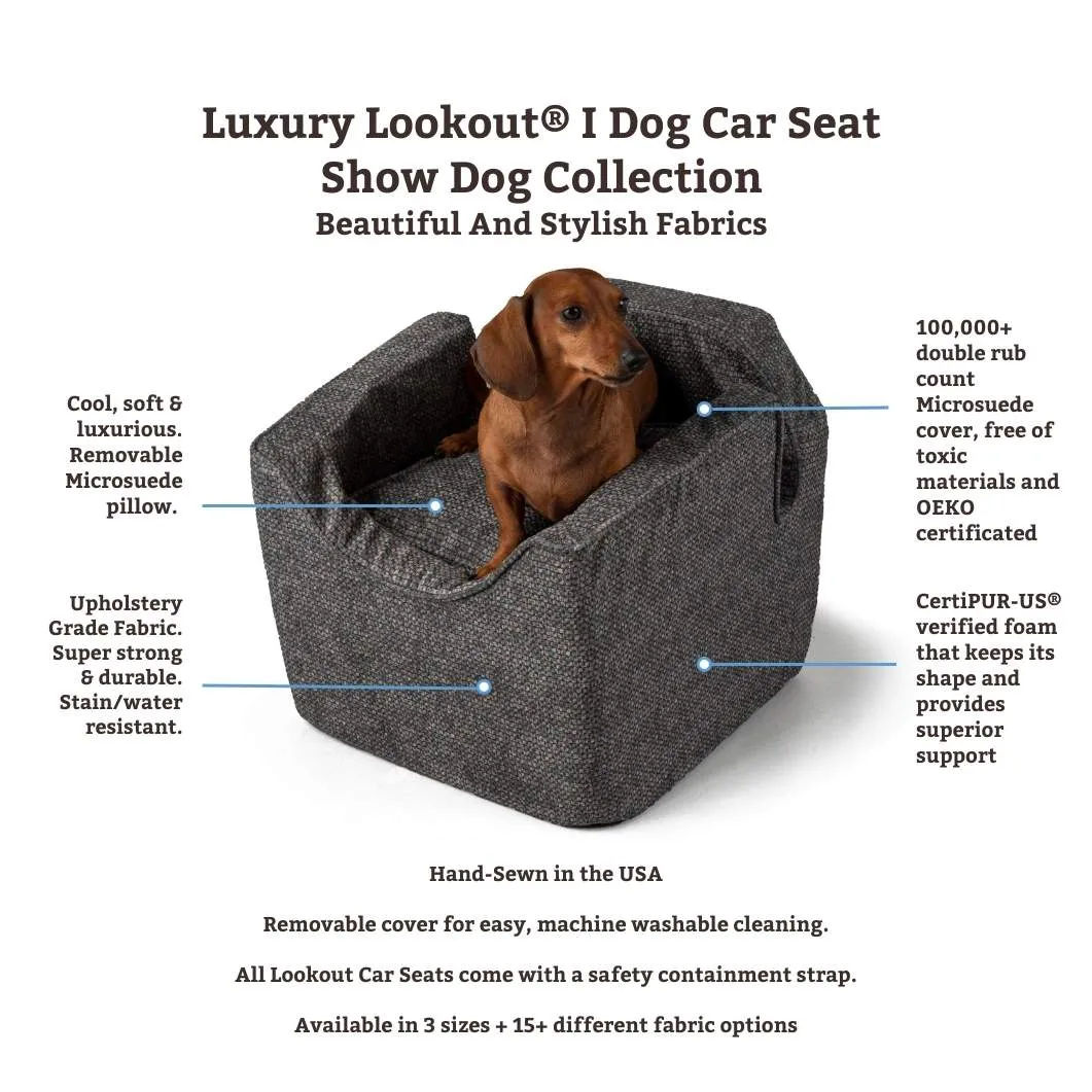 A small dog looking out of a car window from a booster seat