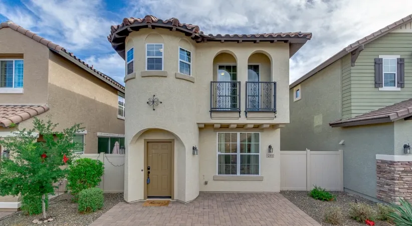 A two-story, stucco, single-family home with a rounded tower-style entrance in Phoenix, Arizona.