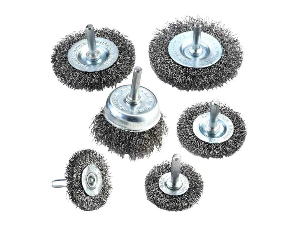 A wire brush being used gently on a car carpet to collect remaining dog hair.