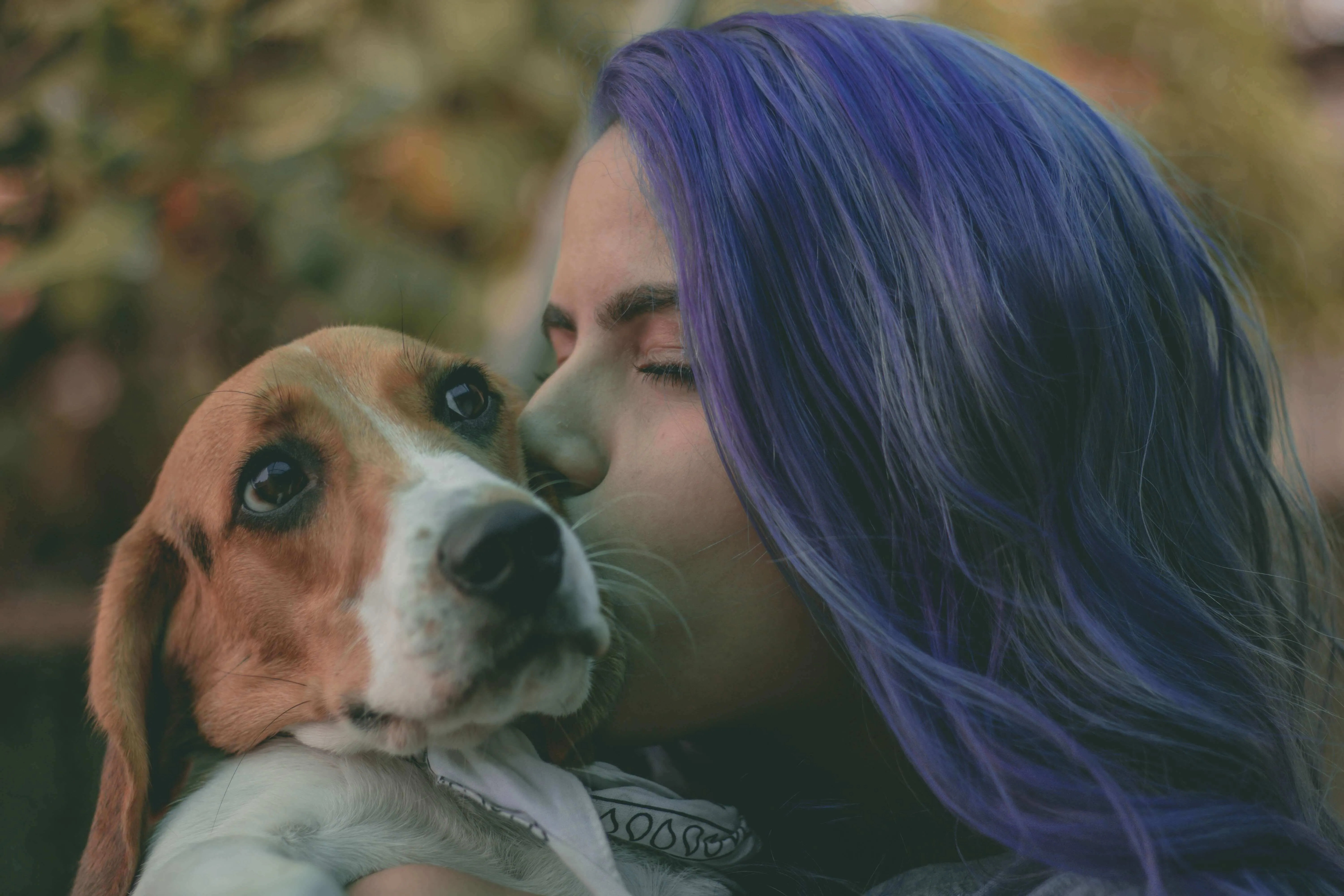 A woman affectionately kissing her pet beagle, representing the rewarding bond of dog ownership despite the financial responsibilities, including potential vet costs in Canada.