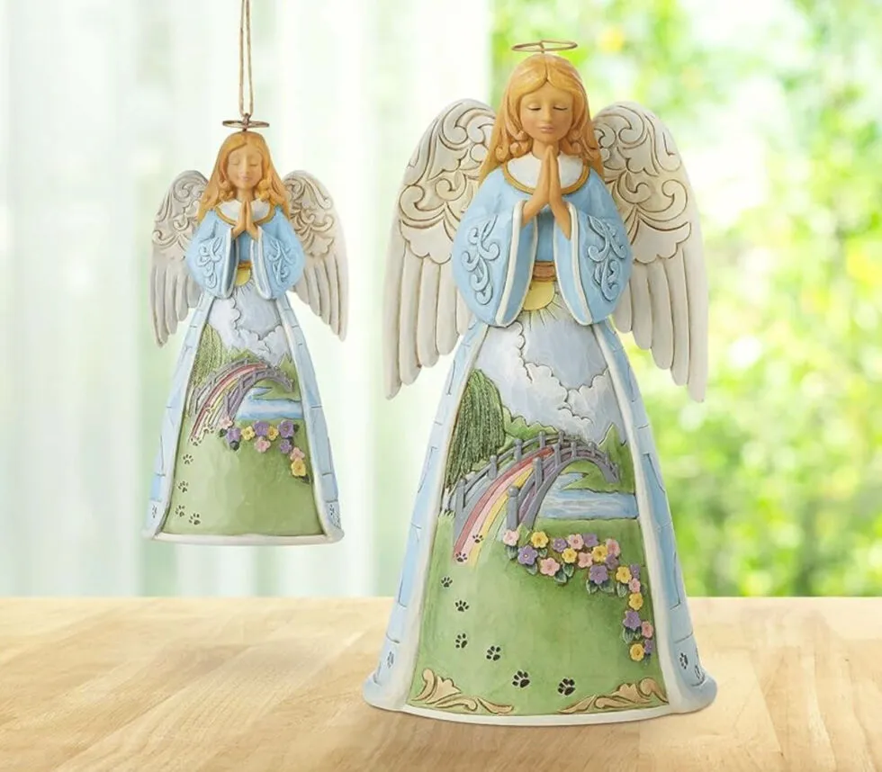 An angel Christmas ornament adorned with paw prints and referencing the Rainbow Bridge.