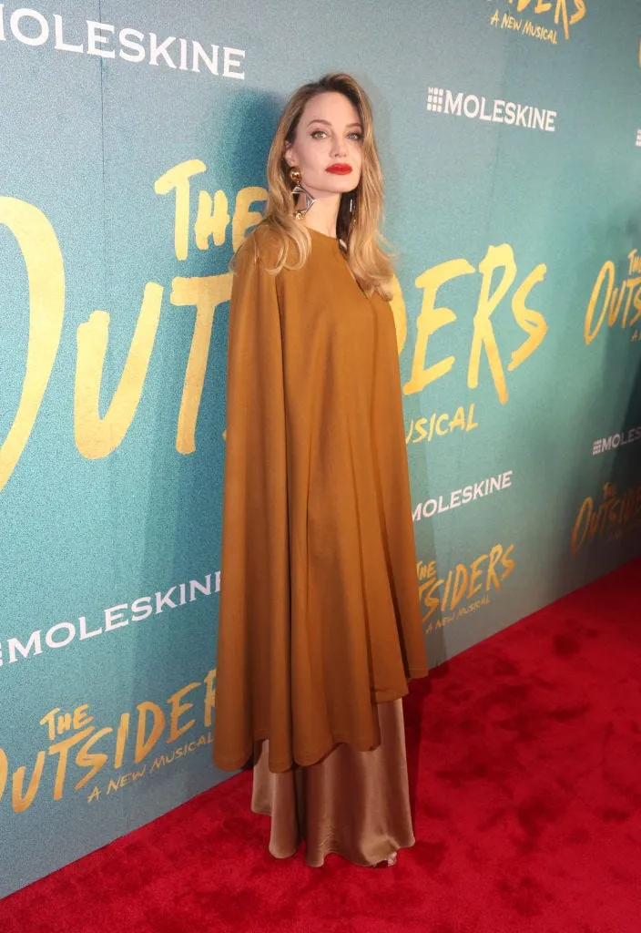 Angelina Jolie on the red carpet wearing a brown gown and cape