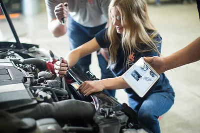 Automotive technicians utilizing advanced diagnostic equipment to service a modern vehicle