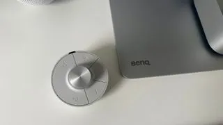 BenQ PD2730S monitor highlighting its wireless Hotkey Puck accessory for easy navigation of settings