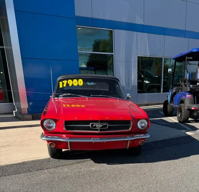Bright Poppy Red 1965 Ford Mustang convertible with black interior and 5-speed manual transmission