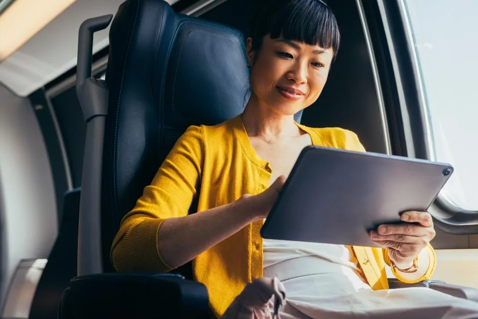 Businesswoman Working on Tablet in Airplane