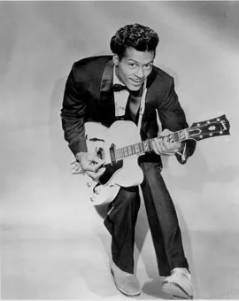 Chuck Berry performing on stage, playing his signature Gibson guitar