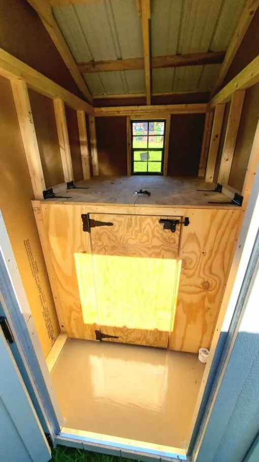 Compact outdoor dog kennel featuring an enclosed shelter and a small outdoor run, suitable for single dogs in a backyard setting.