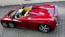 Covini C6W driving on a road, showcasing its unique six-wheel design and exotic appeal.