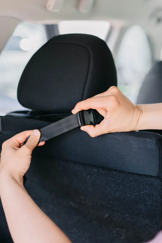 Demonstration of the DGS Pet dog car seat cover's fit across the back seat, highlighting its universal design.