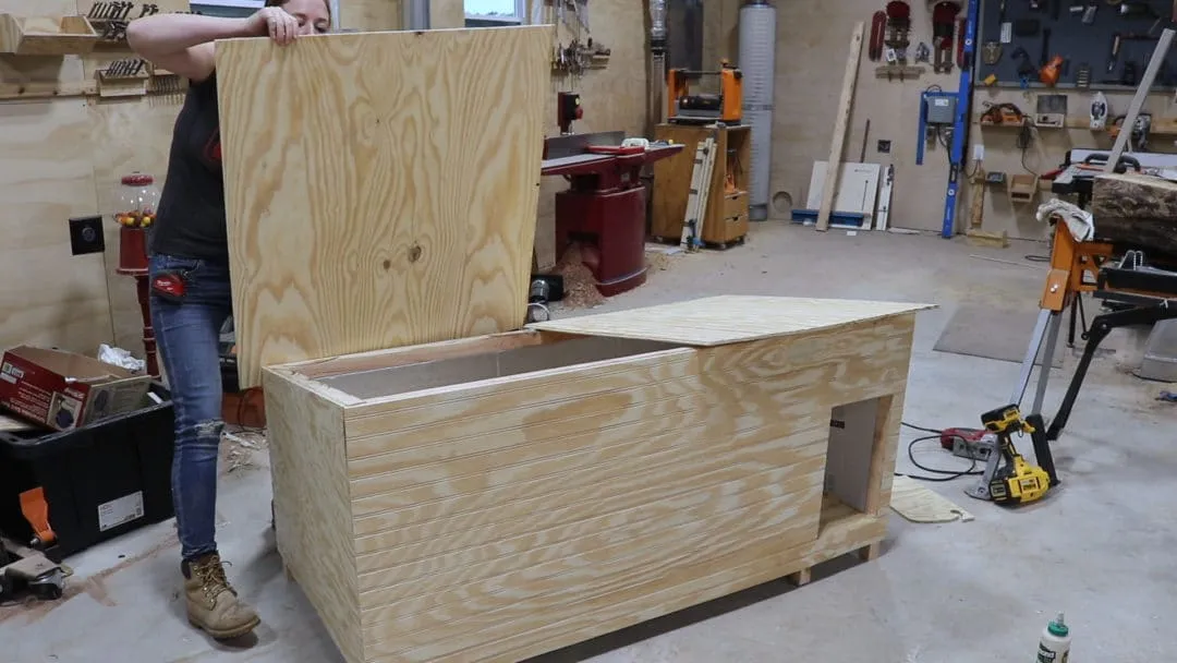 Dog house with hinged roof panels