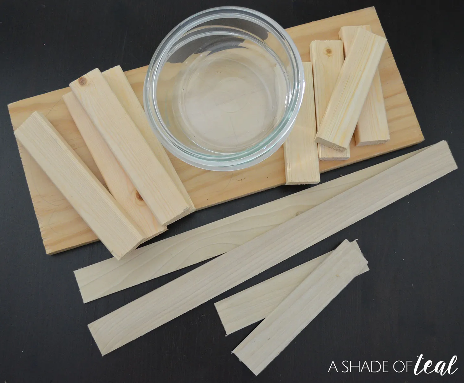 Drilling a pilot hole in a wooden board, a crucial step for creating bowl openings in a raised dog feeder