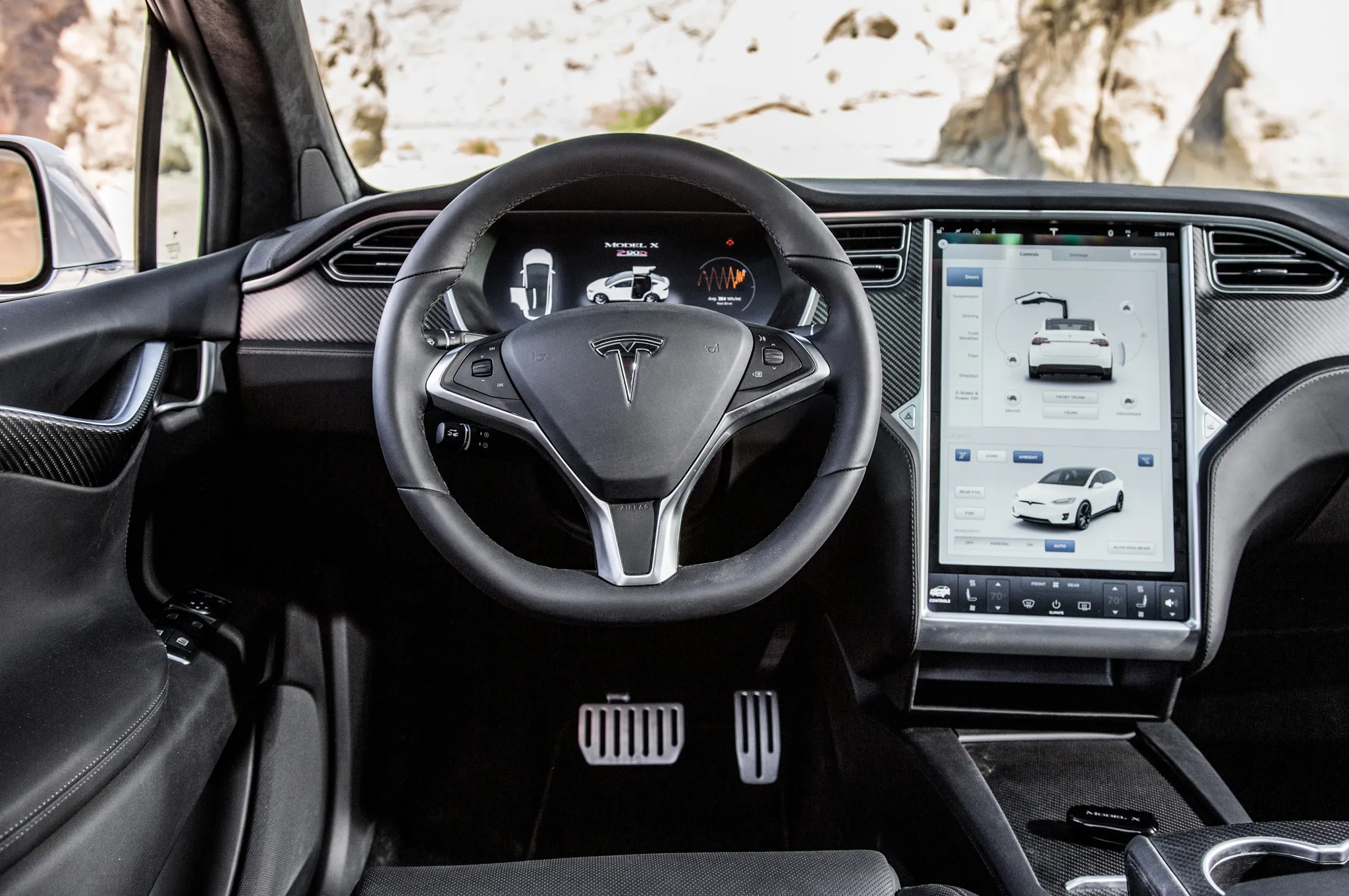 Driver's cockpit view of the Tesla Model X, highlighting the expansive central touchscreen and minimalist design
