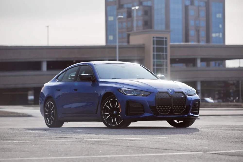 Front three-quarter view of the 2022 BMW i4 M50 in a dynamic pose, highlighting its distinctive kidney grille and sleek electric sedan design.
