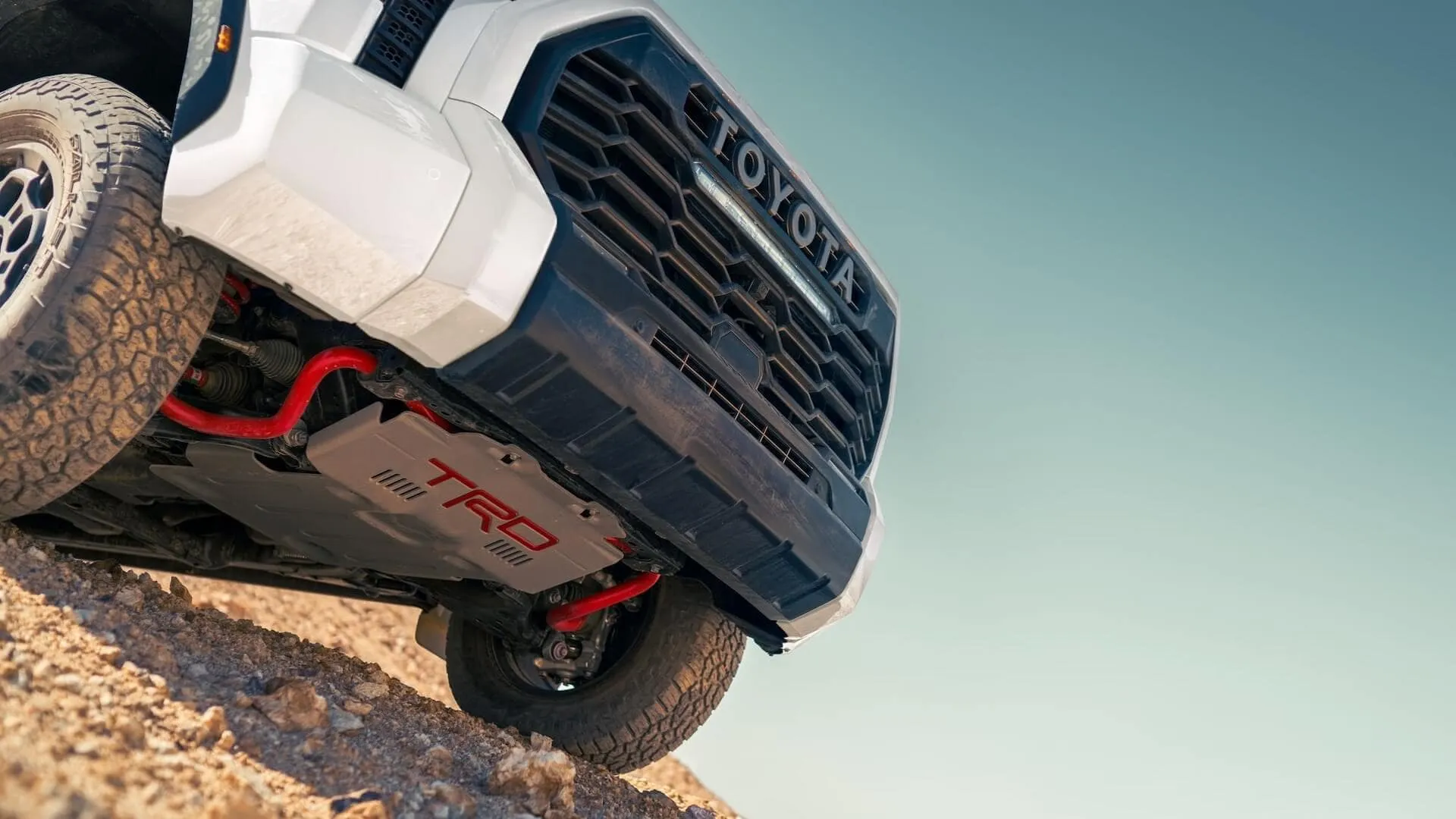 Front three-quarter view of the 2024 Toyota Tundra Hybrid TRD Pro, highlighting its distinctive black heritage grille and aggressive stance.