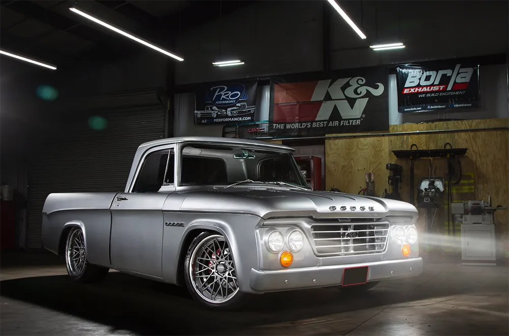Front view of a custom 1962 Dodge D100 Sweptline resto-mod pickup, powered by a modern 6.1L Hemi V8 engine and featuring significant suspension and interior upgrades