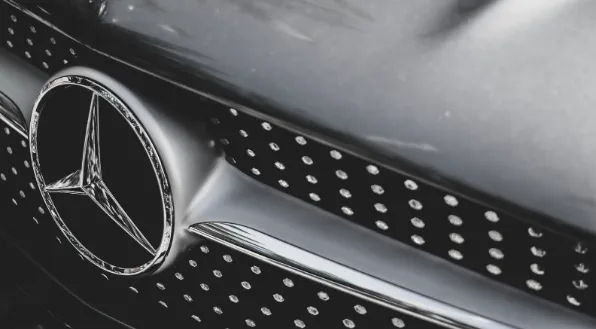 Front view of a Mercedes-Benz luxury sedan, showcasing its iconic grille and elegant lines.