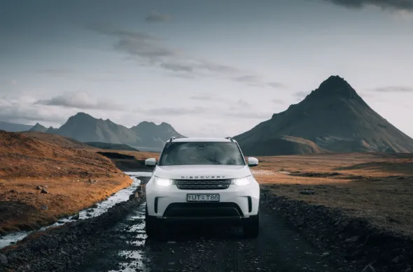 Frontal view of a Land Rover Discovery luxury SUV, highlighting its robust design and premium off-road capability.