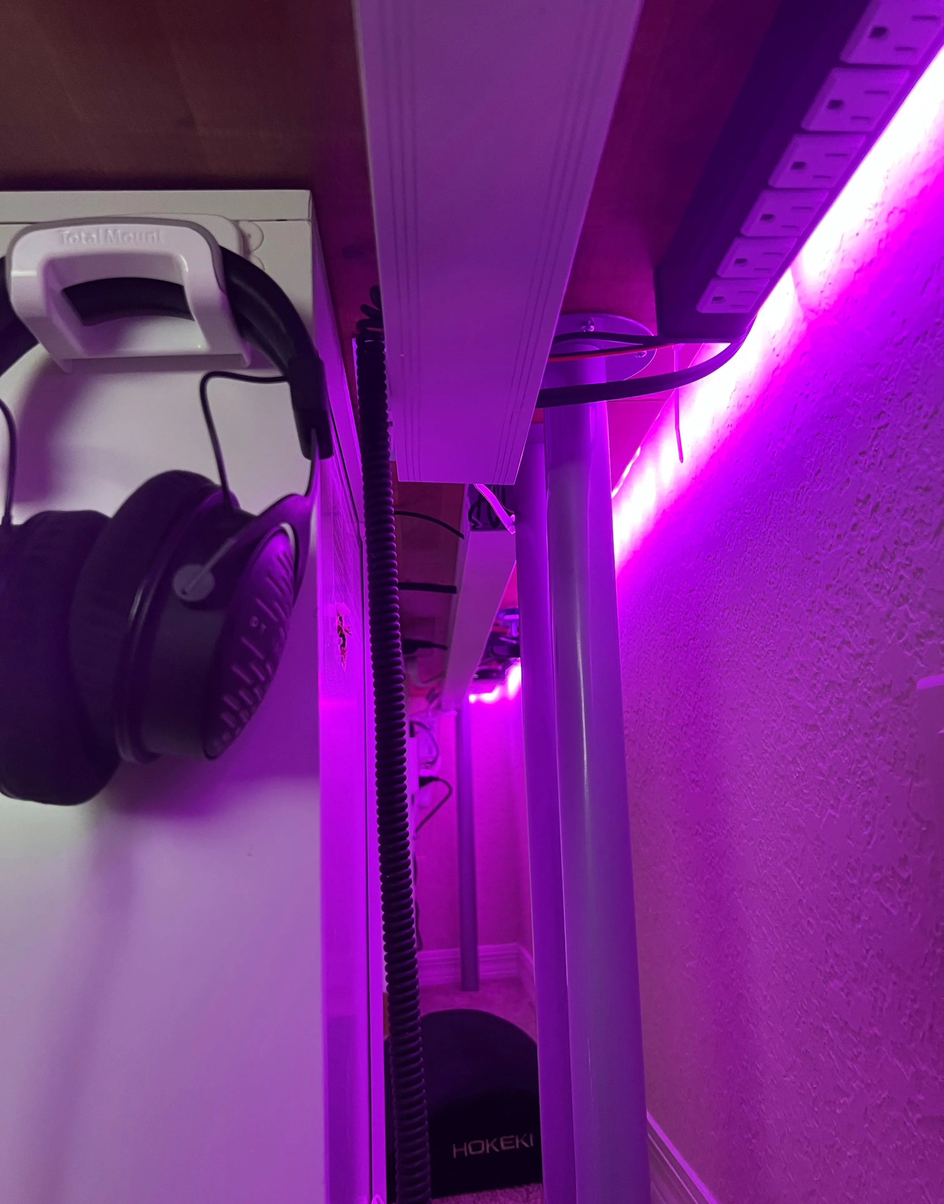Headphones hidden under the desk with cable management