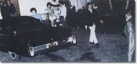Historic photograph of Elvis Presley meeting The Beatles in 1965, featuring Elvis interacting with John Lennon and other band members, a pivotal moment in music history.