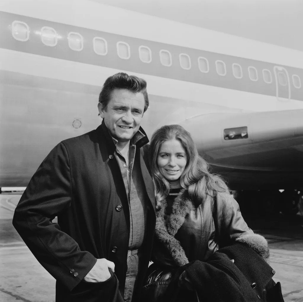 Johnny Cash and June Carter, a powerful duo in Oldies music, sharing a tender moment backstage during their early touring days