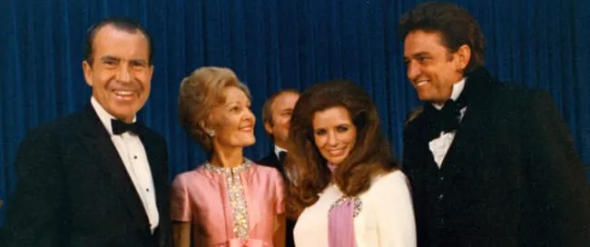 Johnny Cash and June Carter Cash on stage with President Richard Nixon and Pat Nixon, reflecting Cash's influence beyond music.