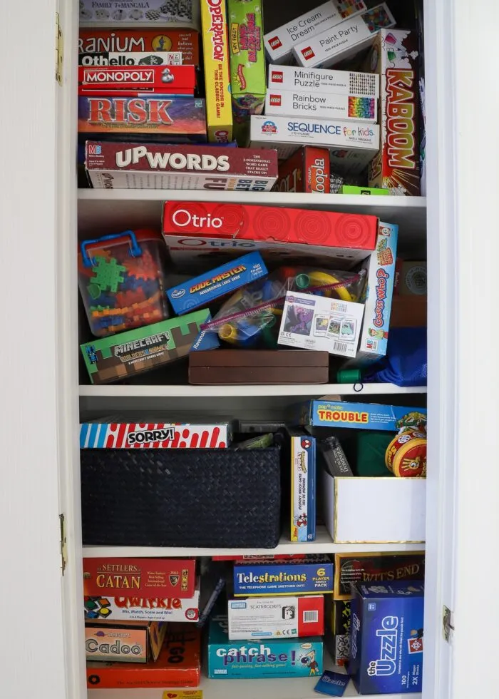 Messy game closet with stacks and stacks of disorganized board games