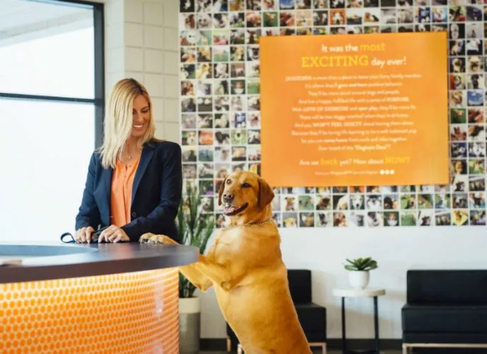 Owner and a dog standing in the lobby at Dogtopia of Las Colinas.