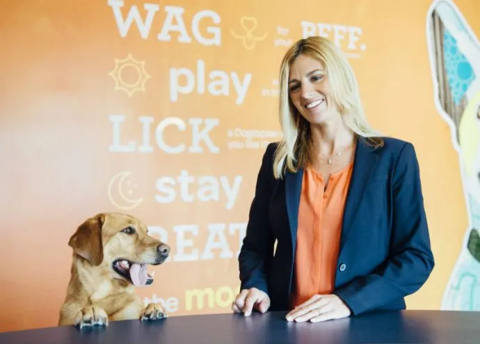 Owner dropping-off a dog at Dogtopia of Las Colinas reception desk.