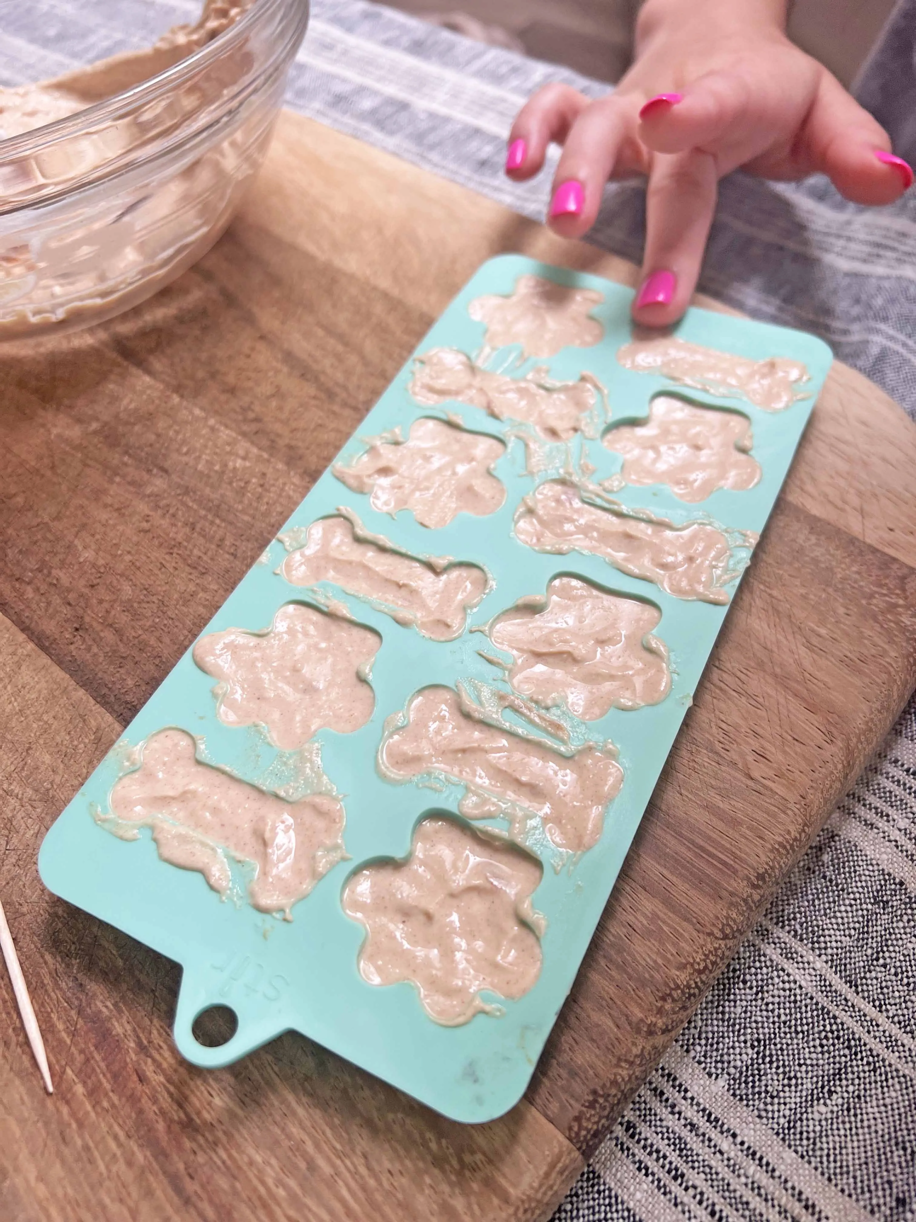 Pressing blueberries into the dog treat mixture in the molds