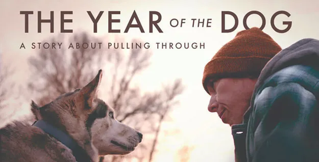 Promotional banner for The Year of the Dog film, featuring a man and his loyal Siberian Husky dog in a snowy Montana landscape, highlighting a story of hope and redemption.