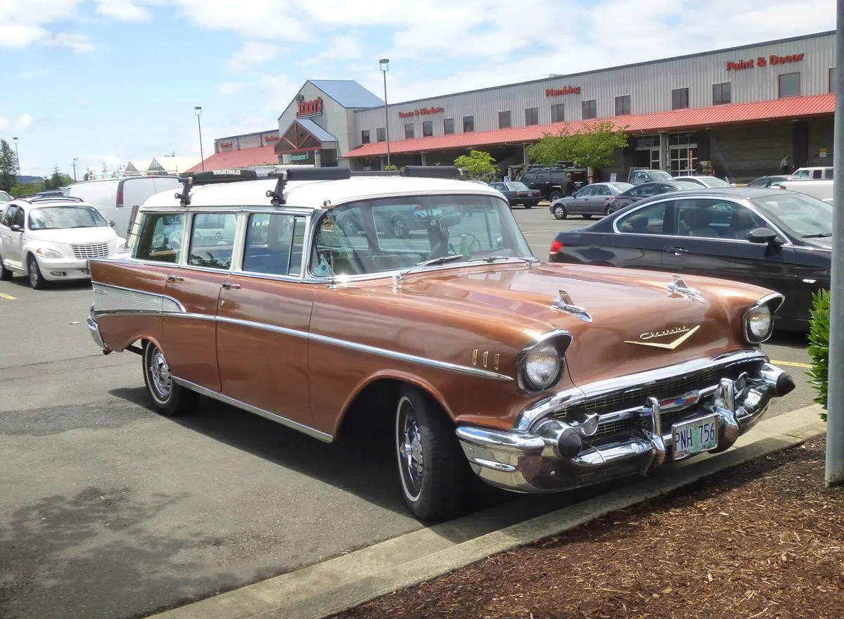 Rear three-quarter view of a vintage 1957 Chevrolet 210 wagon on a street, showcasing its solid build.