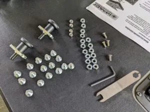 Removable cart and wheels for an Impact Dog Crate being assembled, showing screws and bolts for attachment.