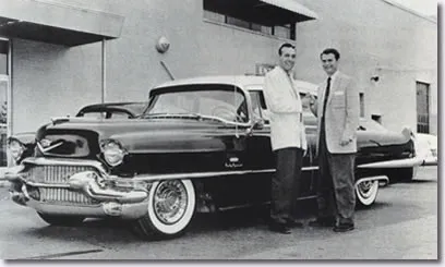Sam Phillips presents Carl Perkins with a Cadillac for "Blue Suede Shoes" selling a million copies